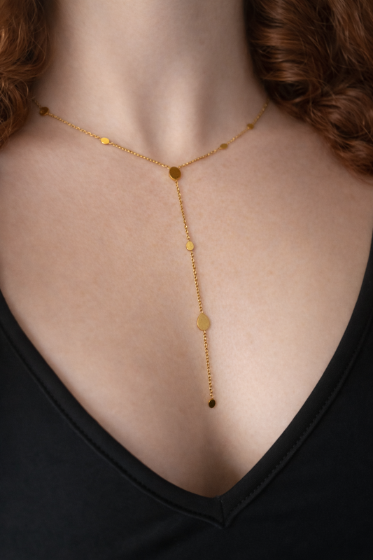 Vergoldete Y-Kette aus Edelstahl mit tropfenförmigen Plättchen, minimalistisch und elegant am Dekolleté getragen
